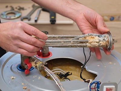 Technician working valves on a water heater