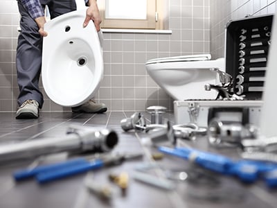 Plumber working at a bathroom fixture